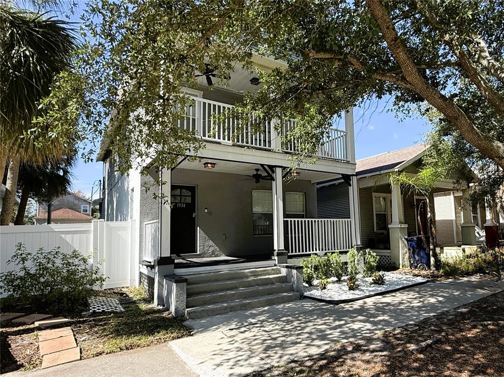 A two-story house with a front porch, balcony, and white picket fence — 1934 W SPRUCE STREET, TAMPA, FL
