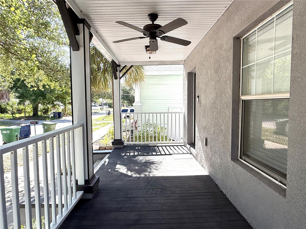 A covered porch features a dark wooden floor, white railings, and a ceiling fan — 1934 W SPRUCE STREET, TAMPA, FL