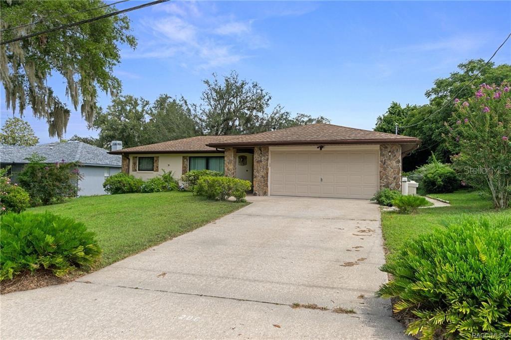A single-story house with a two-car garage, stone accents, and a concrete driveway — 206 HEMLOCK STREET, INVERNESS, FL