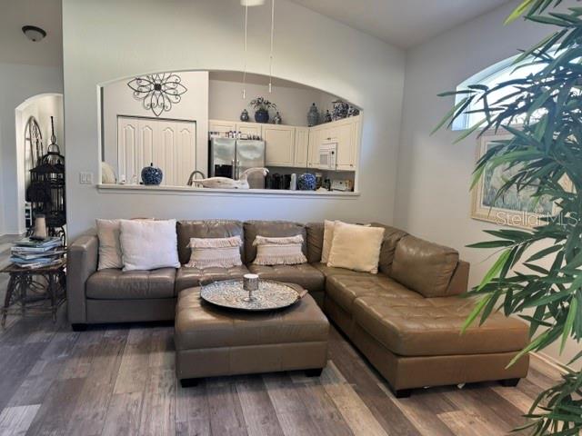 A living room features a brown leather sectional sofa, a matching ottoman, and an arched opening — 16 SUMMER TERRACE UNIT 16, PALM COAST, FL