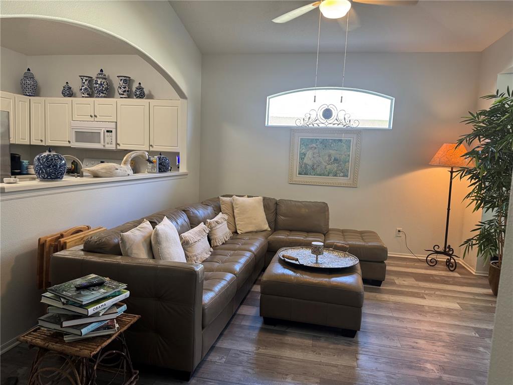 A living room features a leather sectional, a wooden side table, and a kitchen pass-through — 16 SUMMER TERRACE UNIT 16, PALM COAST, FL