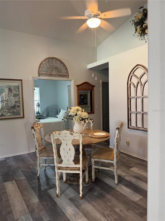 A dining area features a round wooden table, distressed chairs, and arched wall decor — 16 SUMMER TERRACE UNIT 16, PALM COAST, FL