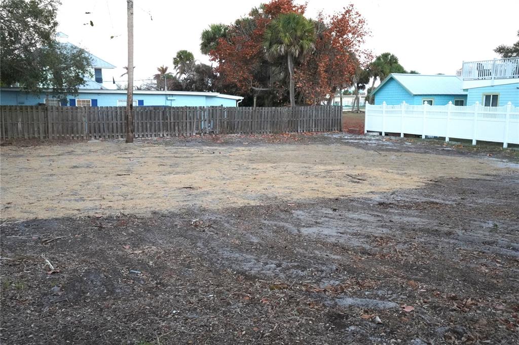 A vacant, cleared residential lot features sandy soil and is enclosed by wooden and white fences — 109 AVENUE D, FORT PIERCE, FL