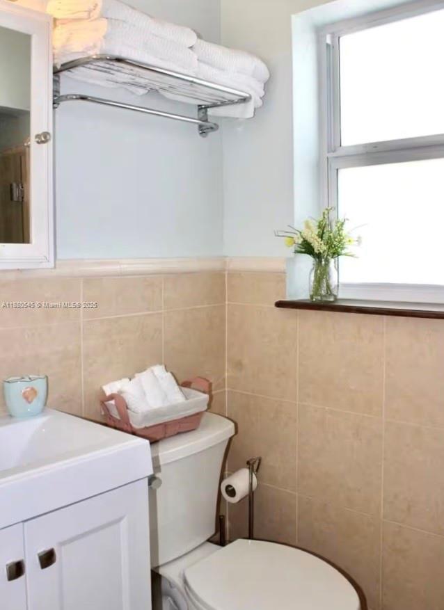 A bathroom features a white vanity, a toilet, a towel rack, and a window — 316 Walnut St # 2, Hollywood FL 33019, HOLLYWOOD, FL