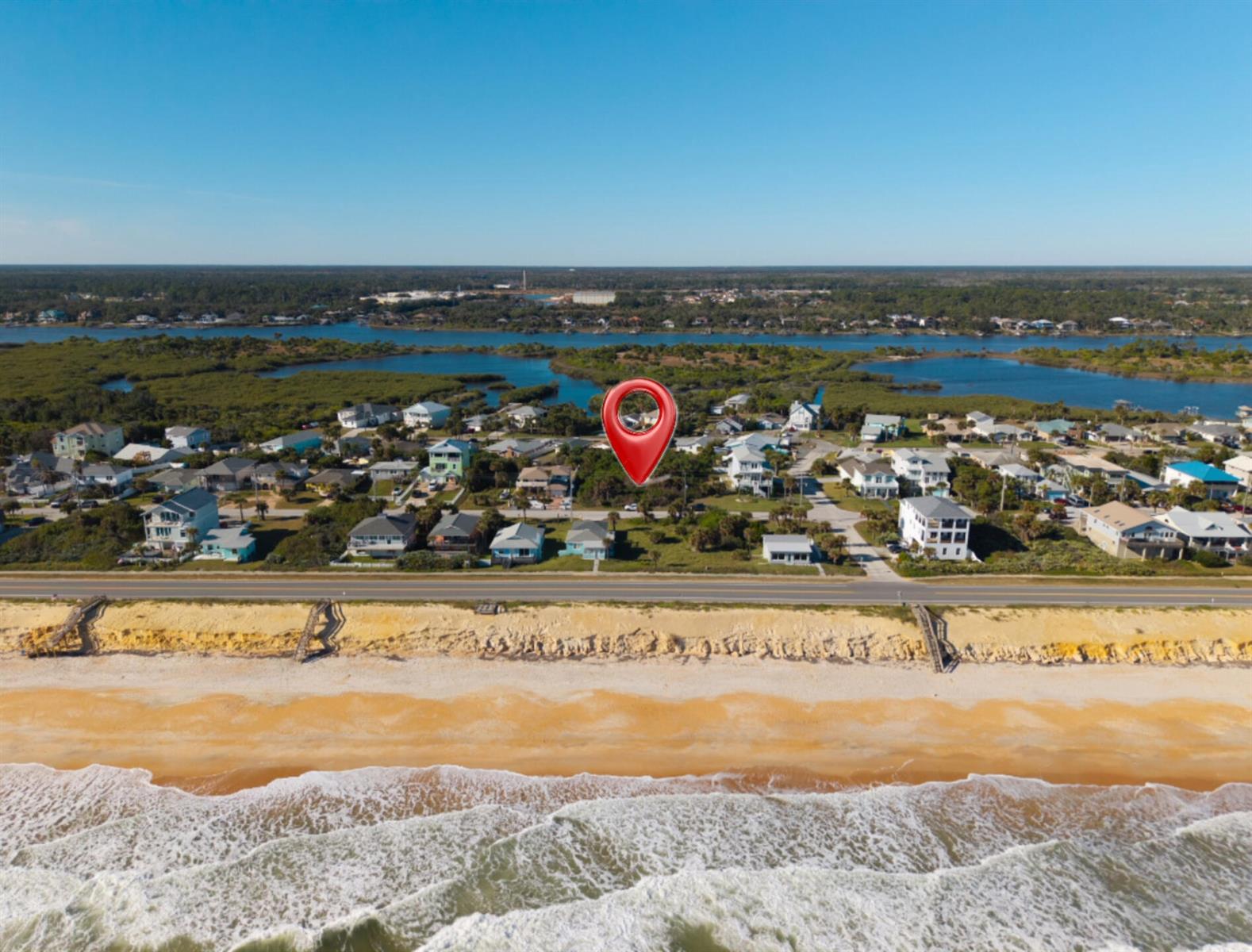 An aerial view shows a beach house marked with a pin near a coastal road — 1945 N Central Avenue, FL 32136, FL