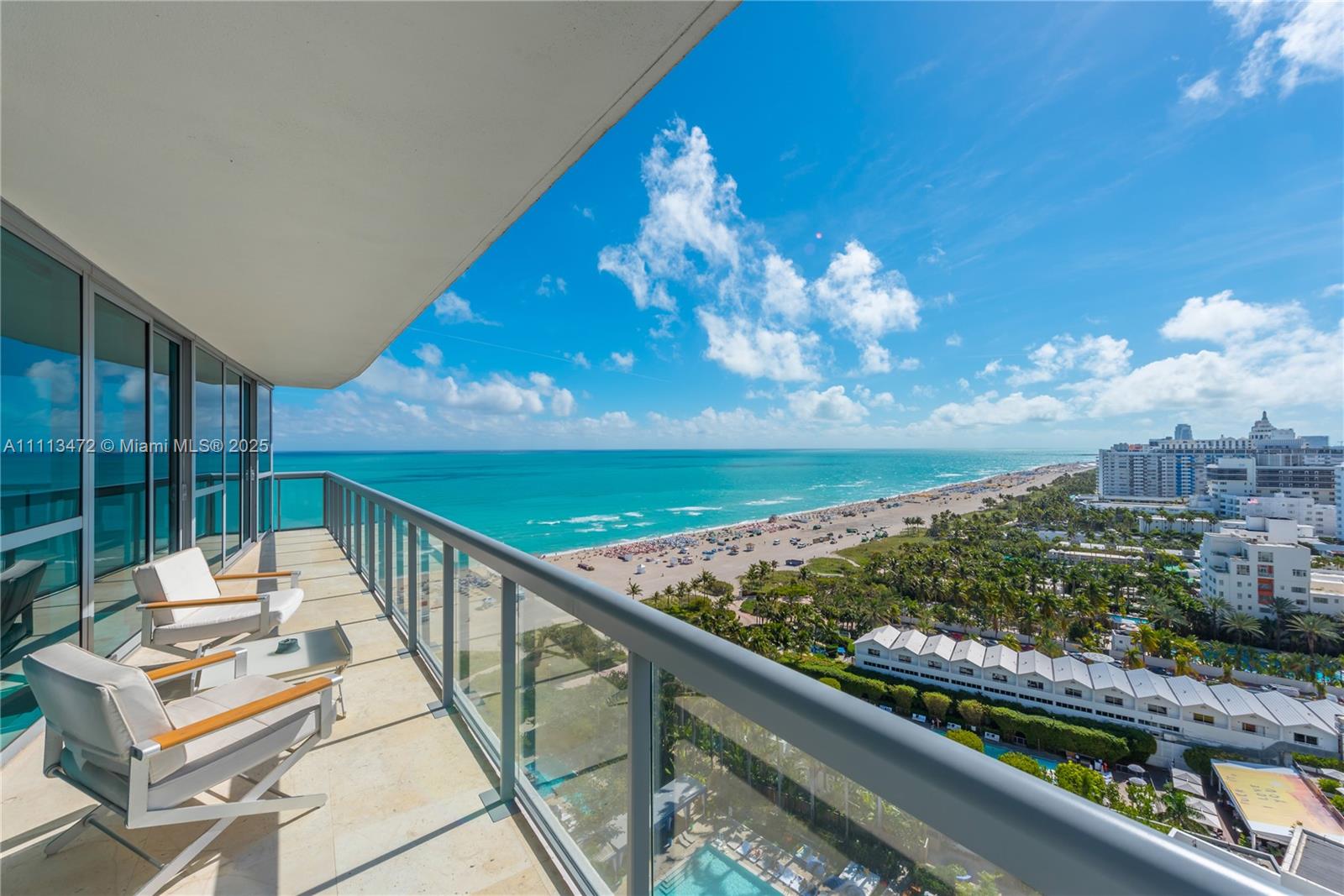A high-rise balcony with two chairs overlooks a sandy beach and the ocean — 101 20th St # 2208, Miami Beach FL 33139, MIAMI BEACH, FL