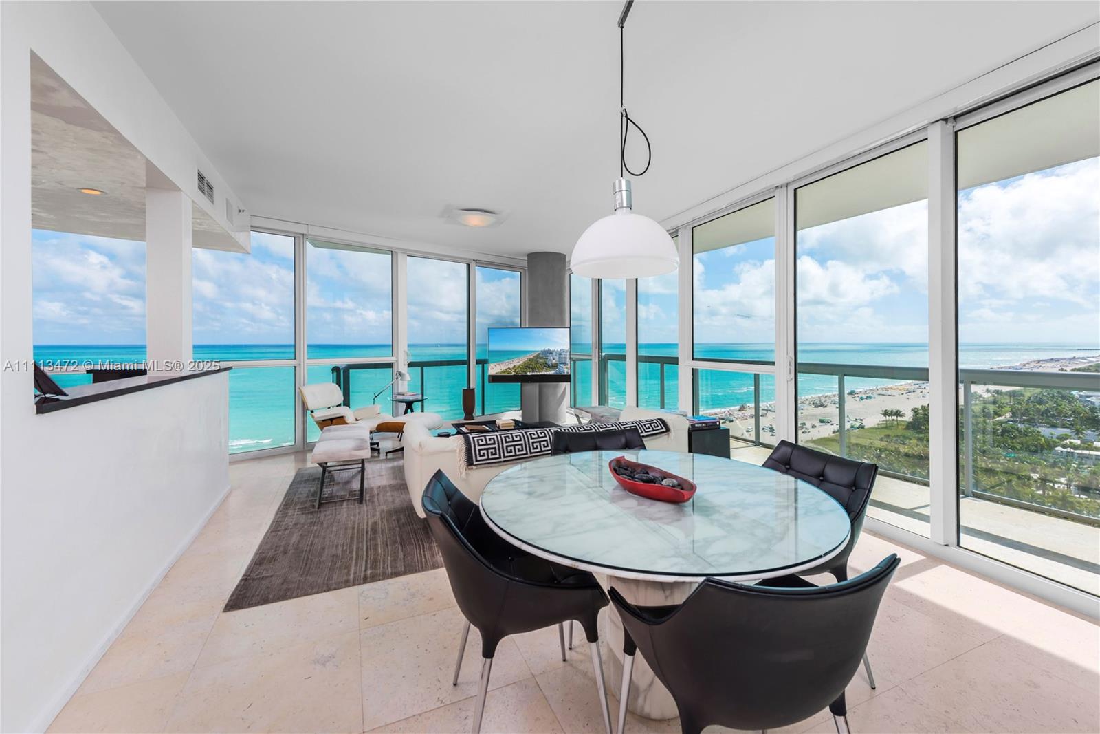 A dining and living area features floor-to-ceiling windows with panoramic ocean and beach views — 101 20th St # 2208, Miami Beach FL 33139, MIAMI BEACH, FL