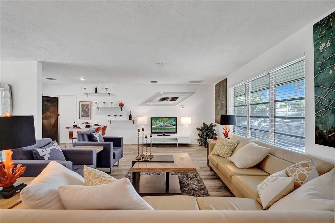 A living room features a beige sectional sofa, a coffee table, and a television console — 5101 NE 27th Avenue, Lighthouse Point FL 33064, LIGHTHOUSE POINT, FL