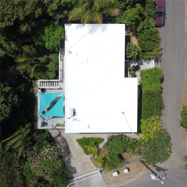 An aerial view shows a house with a white flat roof and a turquoise shade sail — 645 CASA RINCON, VIEQUES, PR