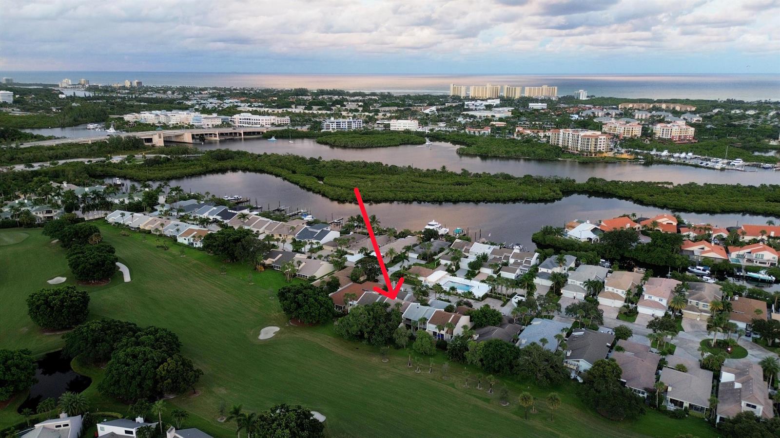 An aerial view shows a residential neighborhood with a red arrow pointing to a townhouse — 17145 Bay Street, Jupiter FL 33477, JUPITER, FL