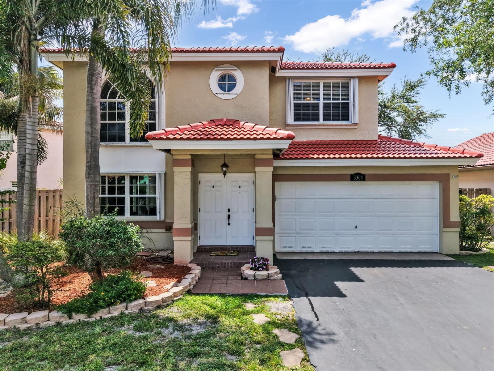 A two-story house with a tan stucco exterior, red tile roof, and a two-car garage — 3364 NW 79th Avenue, Margate FL 33063, MARGATE, FL