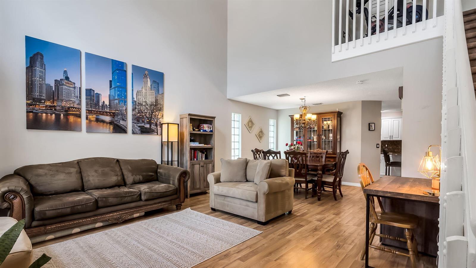 A living room with high ceilings, a brown sofa, and a dining area in the background — 3364 NW 79th Avenue, Margate FL 33063, MARGATE, FL