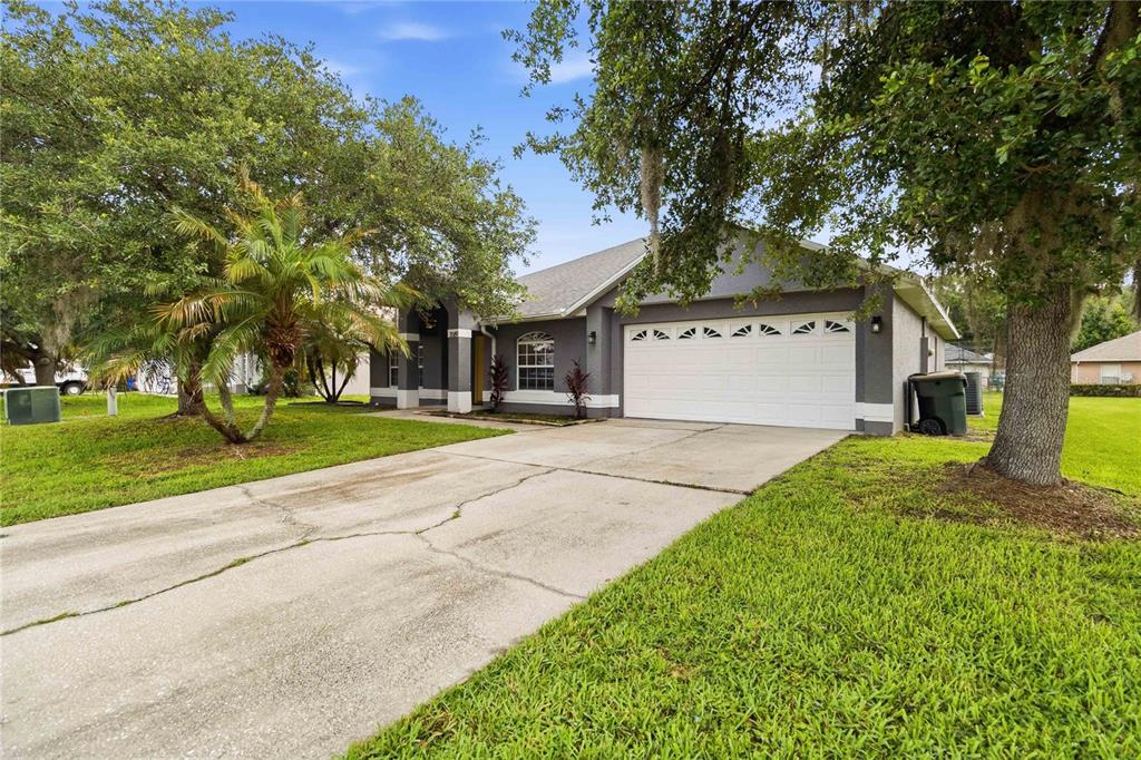 A gray single-story house with a two-car garage and a concrete driveway — 3589 YELLOW BIRD COURT, ST CLOUD, FL