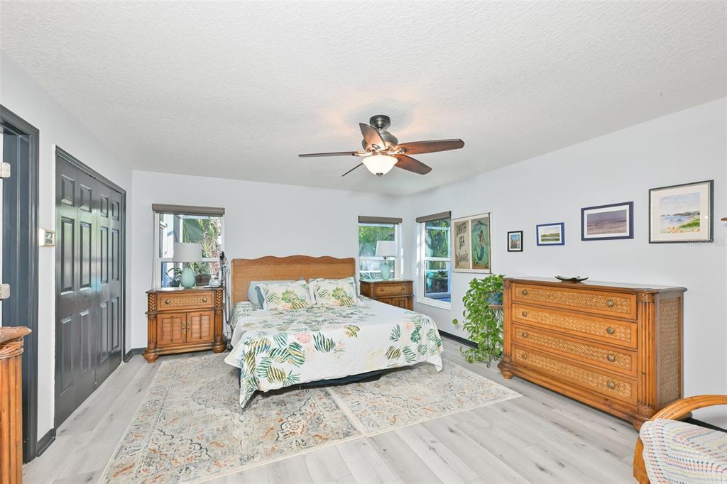 A bedroom features a bed with a wicker headboard, wooden furniture, and light-colored flooring — 4061 KINGSFIELD DRIVE, PARRISH, FL