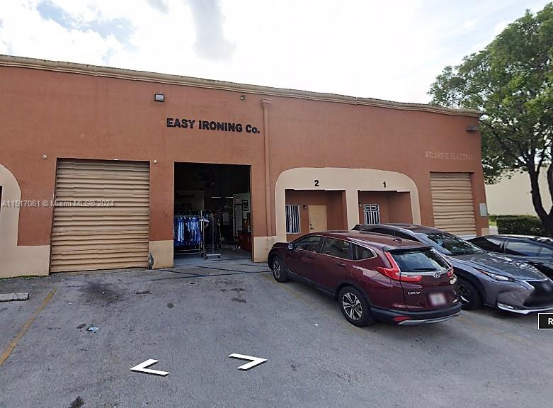 The exterior of a commercial building features a large open bay and two numbered entrances — 8055 W 23rd Ave #2, Hialeah FL 33016, HIALEAH, FL