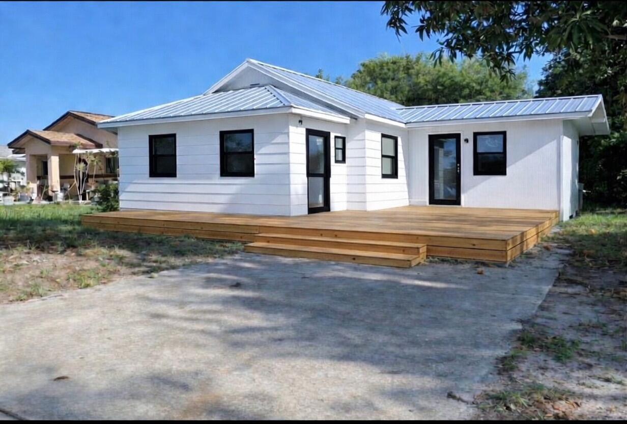 A white house with a metal roof and a large wooden deck in front — 156 Pearl Street, Boca Raton FL 33432, BOCA RATON, FL