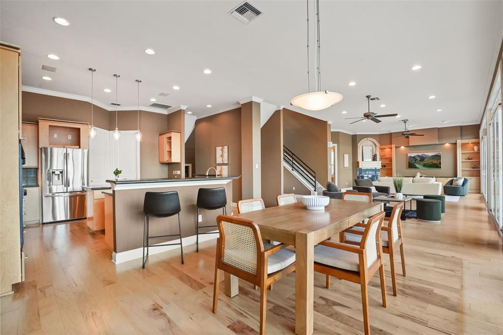 An open-concept kitchen, dining area, and living room featuring hardwood floors and neutral walls — 1166 N LAKE SYBELIA, MAITLAND, FL