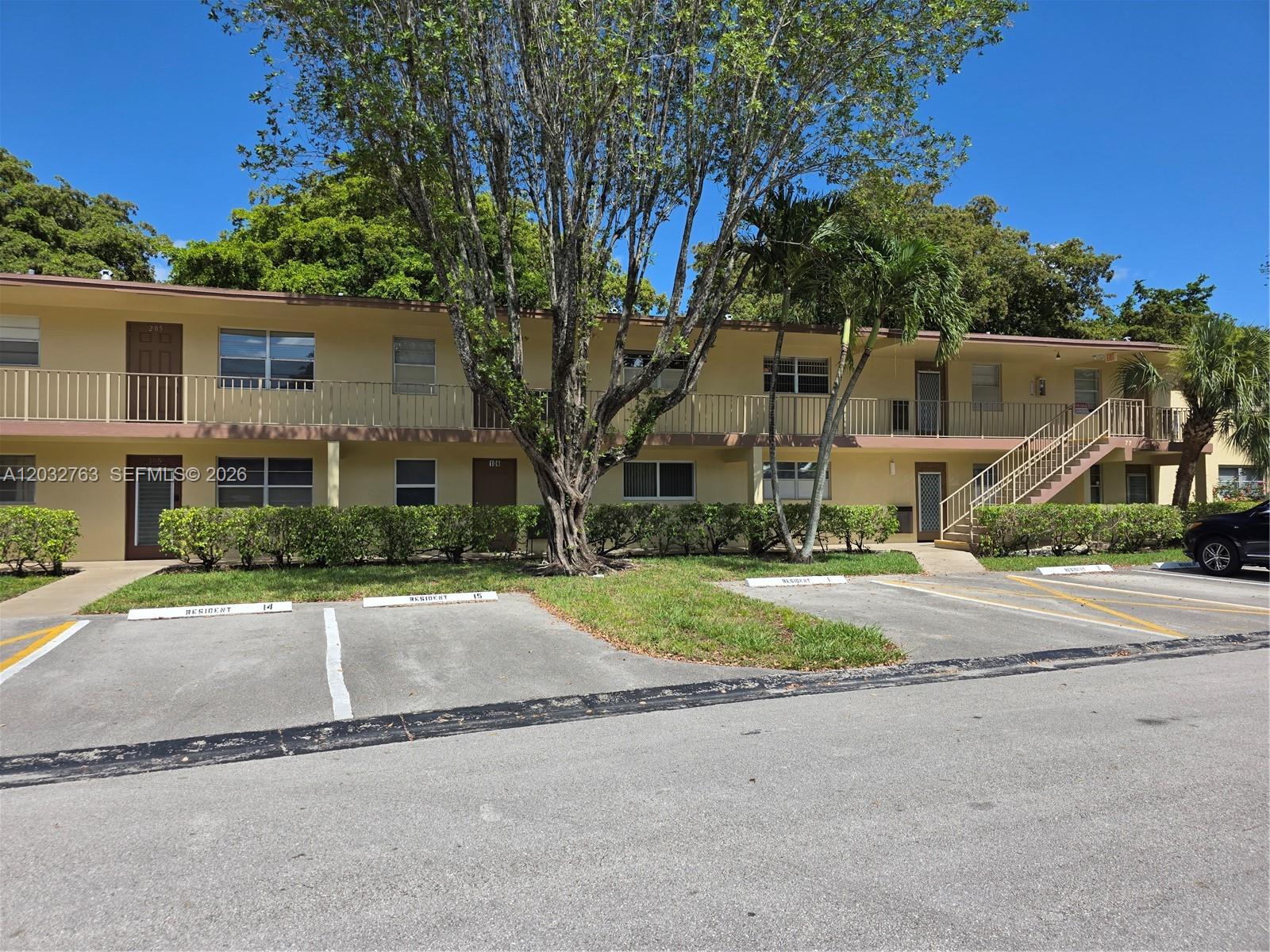A two-story apartment building with a parking lot and a large tree in front — 251 NW 76th Ave # 106, Margate FL 33063, MARGATE, FL