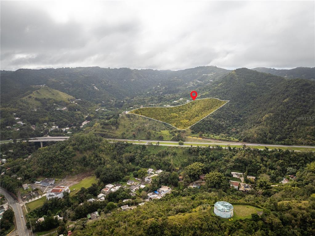An aerial view shows a highlighted plot of land situated next to a highway — KM.HM 59 3 CARR 1, BO QUEBRADA ARRIBA, CAYEY, PR