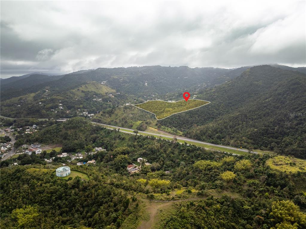 An aerial view shows a highlighted plot of land on a lush, mountainous hillside — KM.HM 59 3 CARR 1, BO QUEBRADA ARRIBA, CAYEY, PR