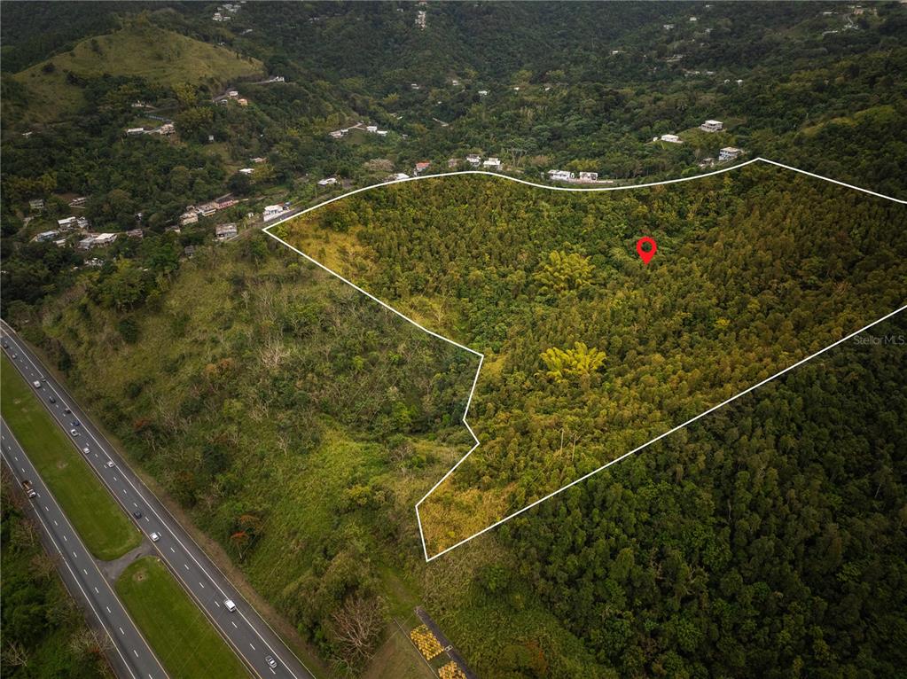 An aerial view shows a highlighted plot of land on a lush, mountainous hillside — KM.HM 59 3 CARR 1, BO QUEBRADA ARRIBA, CAYEY, PR