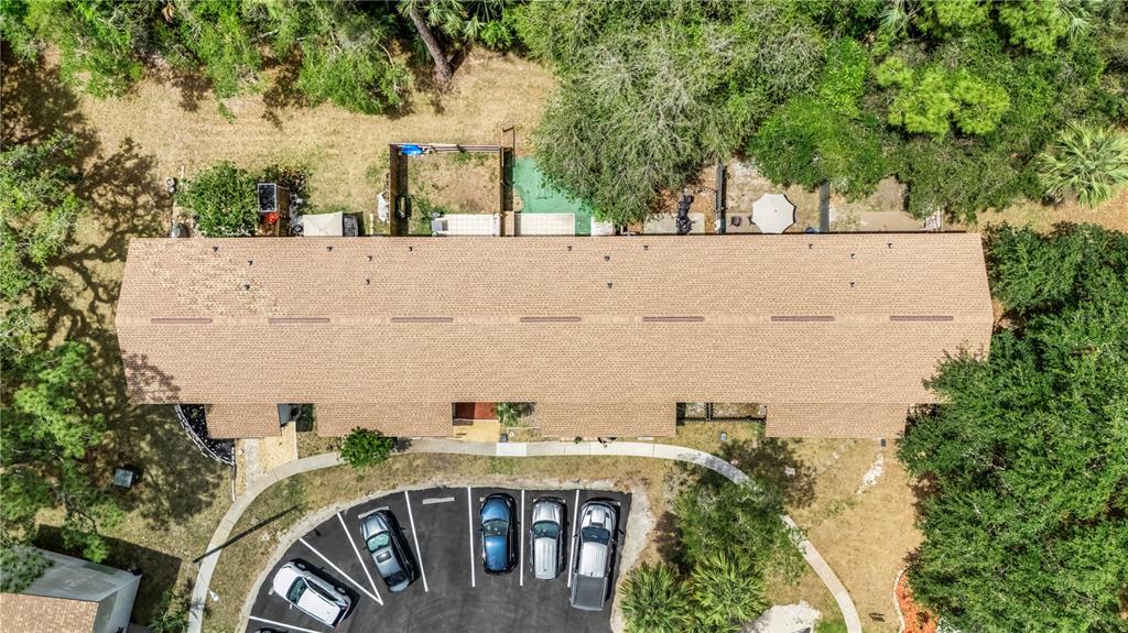 An aerial view shows a long residential building with a shingled roof and parking lot — 322 CANAL ROAD UNIT D22, EDGEWATER, FL