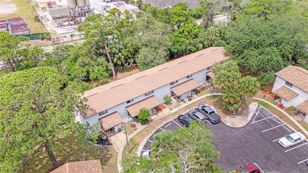 An aerial view shows a multi-unit residential building with a brown roof and parking lot — 322 CANAL ROAD UNIT D22, EDGEWATER, FL