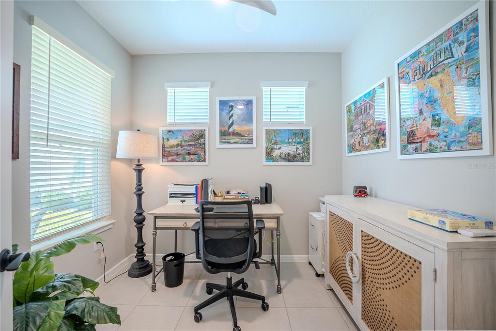 A home office features a desk, an office chair, a side cabinet, and wall art — 8764 SW 58TH STREET ROAD, OCALA, FL