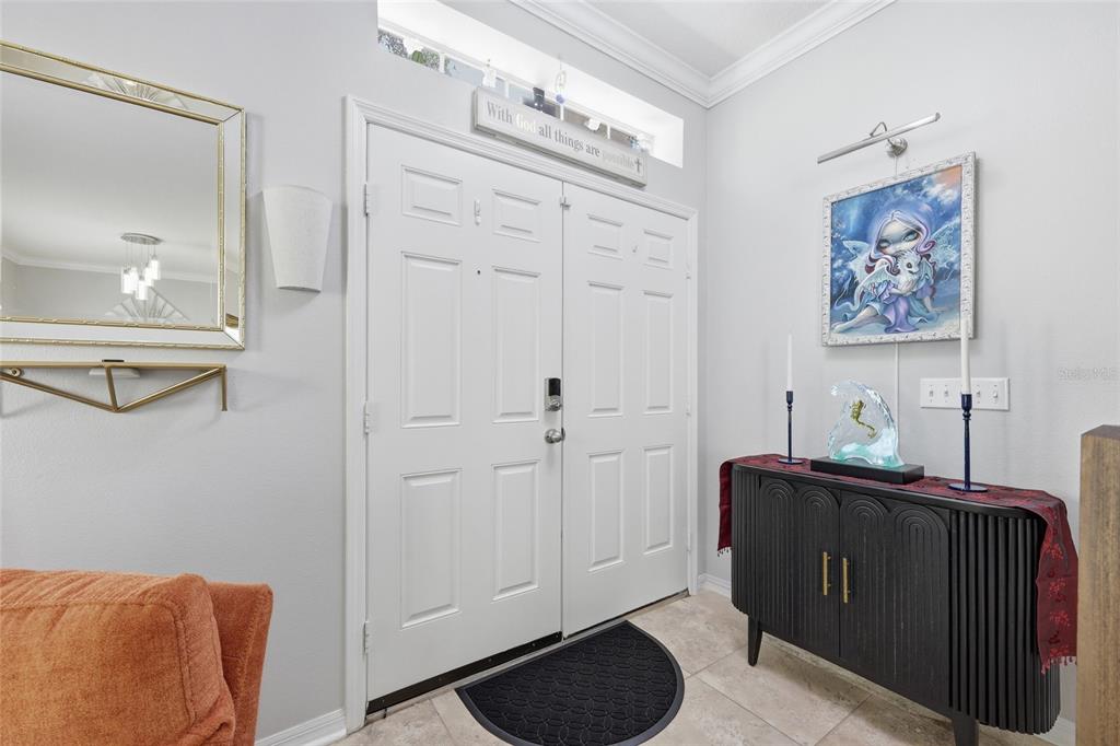An entryway features double white doors, a black console table, and a mirror on the wall — 12515 SAWGRASS OAK STREET, ORLANDO, FL