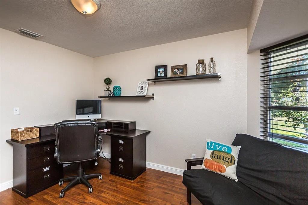 A home office features a dark wood desk, a black chair, shelving, and a futon — 13920 JAMAICA DRIVE, SEMINOLE, FL
