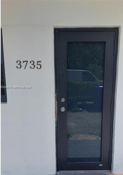 A white exterior wall features the number 3735 next to a dark-framed glass door — 3735 NW 21st Ct # 3735, Miami FL 33142, MIAMI, FL
