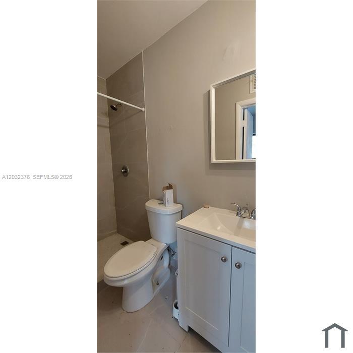 A bathroom features a white vanity, a toilet, and a tiled walk-in shower — 3735 NW 21st Ct # 3735, Miami FL 33142, MIAMI, FL