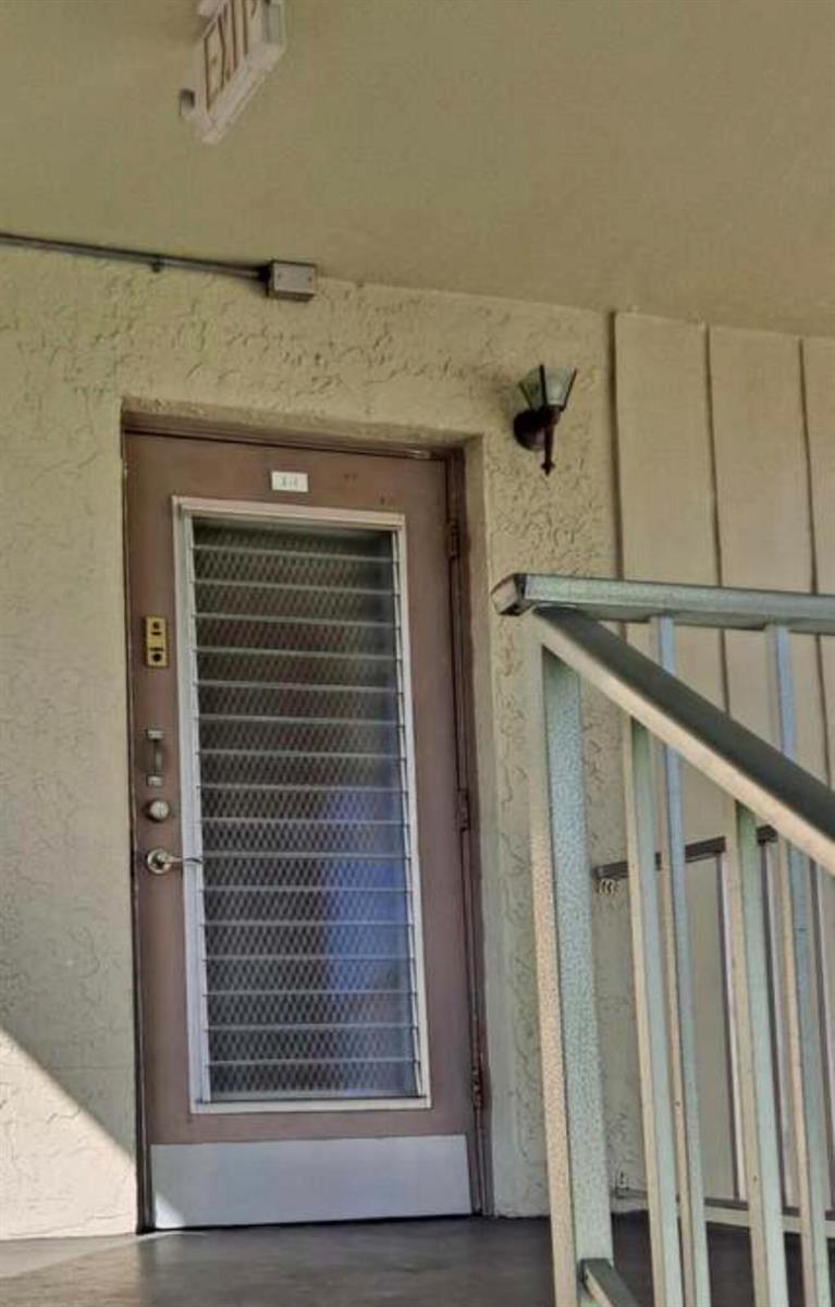 An exterior view of a building entrance featuring a door with a louvered glass insert — 603 S State Road 7 # 2i, Margate FL 33068, MARGATE, FL