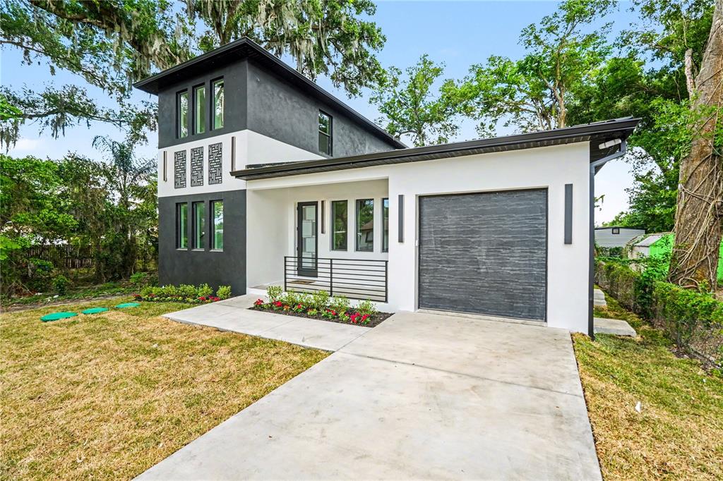 A modern two-story house with a white and dark gray exterior and a single-car garage — 105 GARLAND AVENUE, SEFFNER, FL