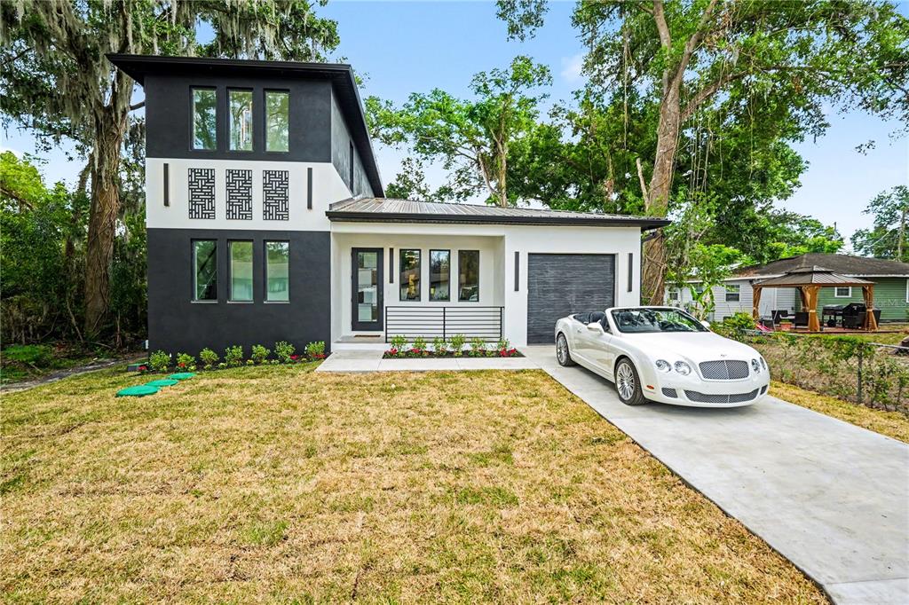 A two-story modern house with a white convertible parked on the concrete driveway — 105 GARLAND AVENUE, SEFFNER, FL