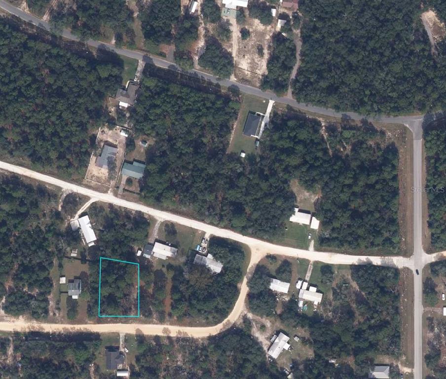 An aerial view shows a vacant, rectangular lot outlined in blue within a wooded neighborhood — 5814 HILLRIDGE ROAD, KEYSTONE HEIGHTS, FL