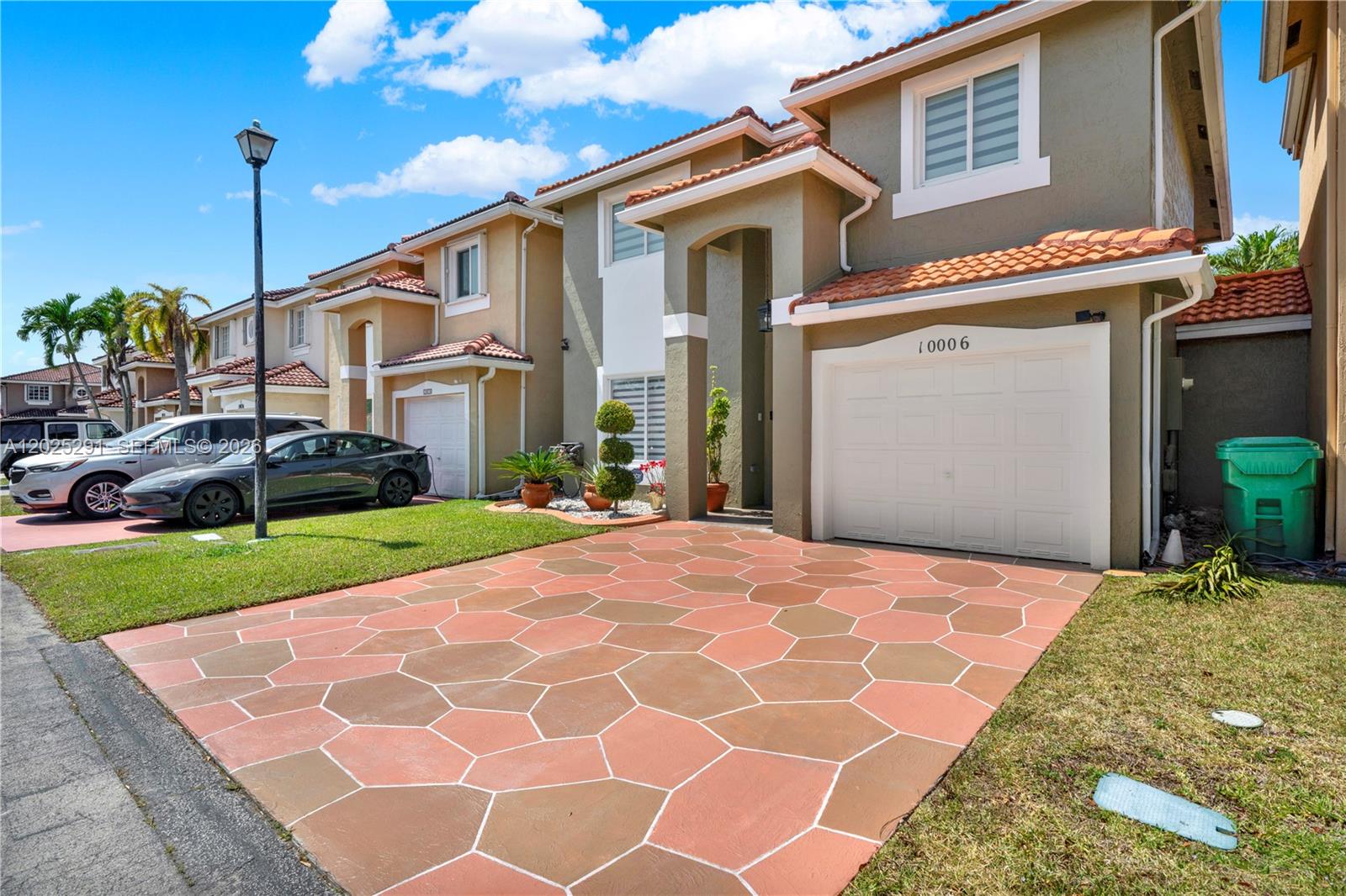 A two-story suburban house features a patterned paver driveway, a one-car garage, and stucco siding — 10006 SW 162nd Path, Miami FL 33196, MIAMI, FL