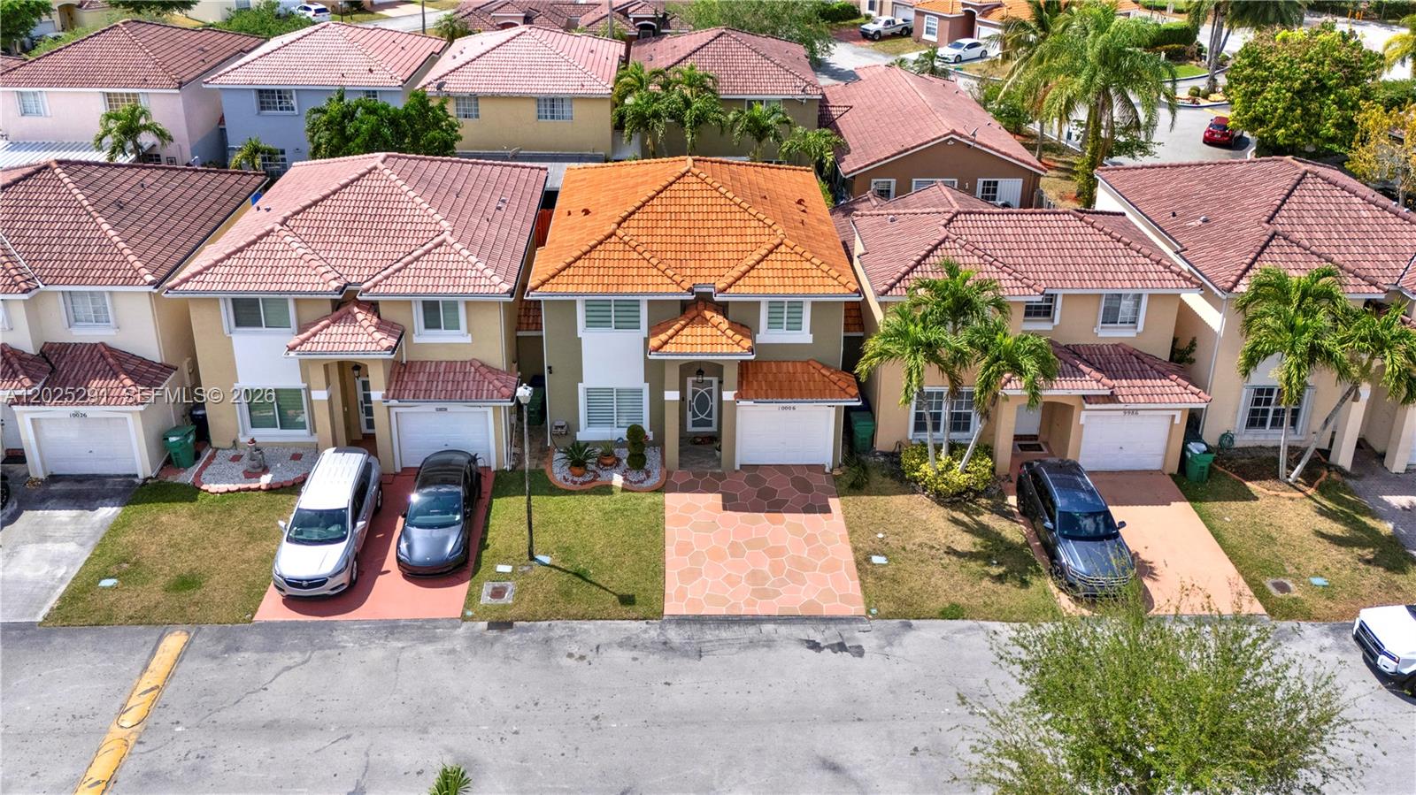 An aerial view shows a row of suburban houses with tiled roofs and paved driveways — 10006 SW 162nd Path, Miami FL 33196, MIAMI, FL