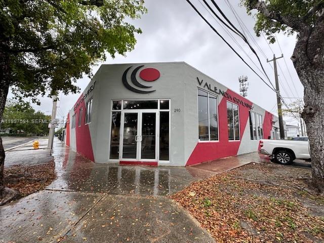 A low-angle exterior view of a commercial building with a red and gray facade — 280 NE 59th St # 290, Miami FL 33137, MIAMI, FL