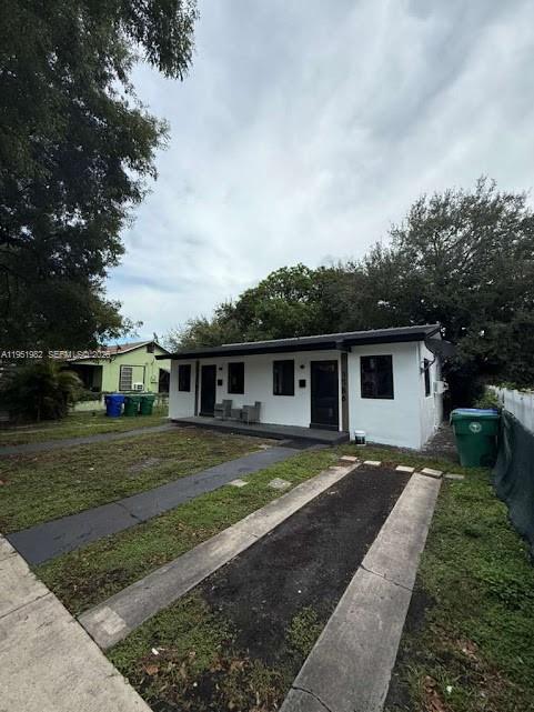 A white single-story house with a flat roof and a paved driveway in front — 1786 NW 53rd St, Miami FL 33142, MIAMI, FL