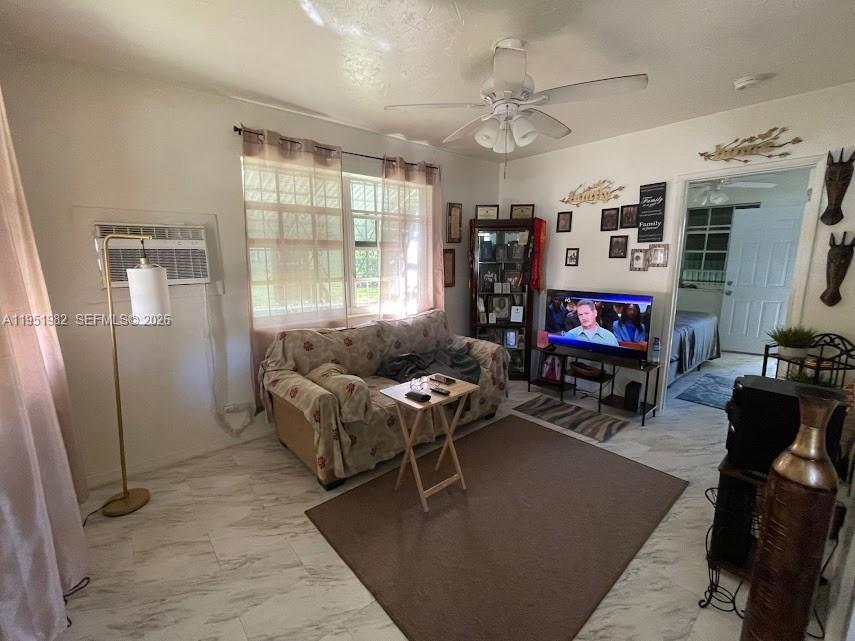 A living room features a sofa, television, ceiling fan, and light-colored tile flooring — 1786 NW 53rd St, Miami FL 33142, MIAMI, FL