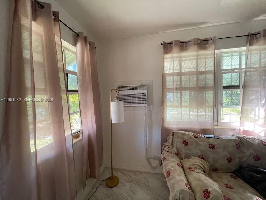 A living room features light-colored tile floors, sheer curtains, a floor lamp, and an air conditioner — 1786 NW 53rd St, Miami FL 33142, MIAMI, FL