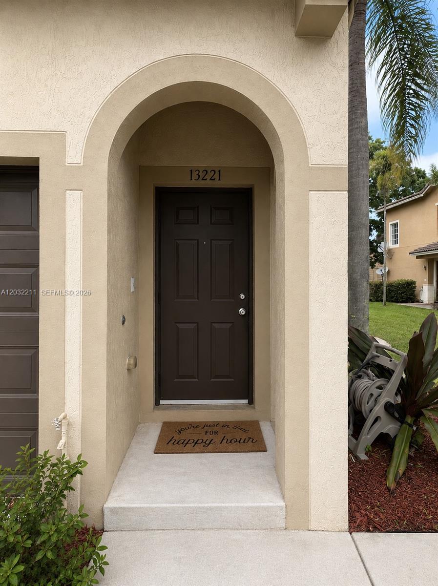 The exterior of a home features a brown front door under an arched entryway — 13221 SW 42nd St # 8203, Miramar FL 33027, MIRAMAR, FL