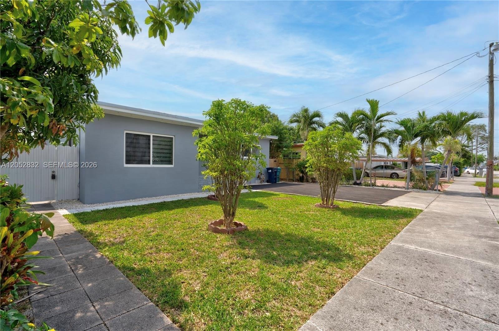 A gray single-story house features a front lawn with two small trees and a driveway — 3635 SW 88th Ct, Miami FL 33165, MIAMI, FL