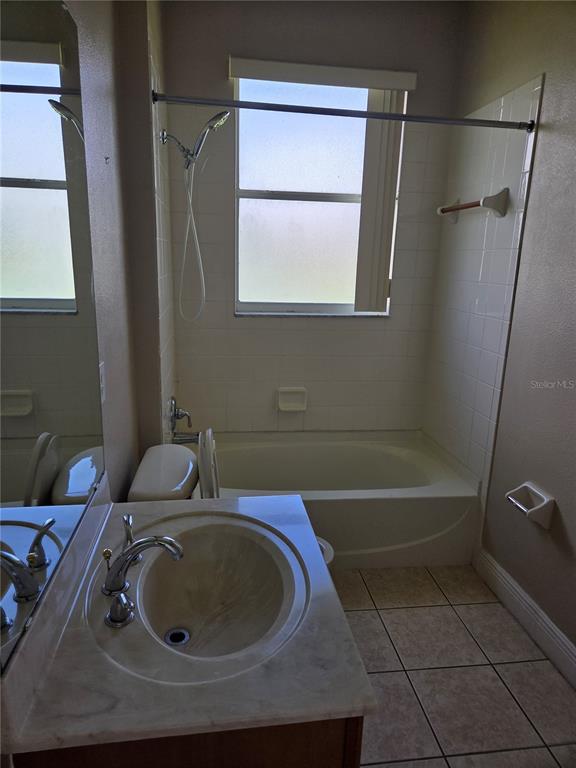 A bathroom features a vanity with a sink, a toilet, and a tub-shower combination — 2770 BOAT COVE CIRCLE, KISSIMMEE, FL