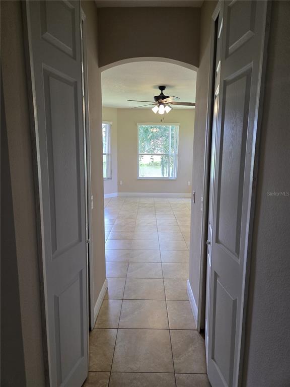 A view through a doorway into a tiled living area with a ceiling fan — 2770 BOAT COVE CIRCLE, KISSIMMEE, FL