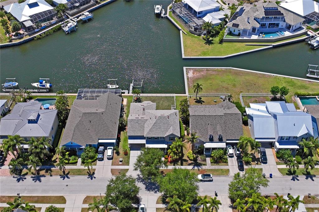 An aerial view shows several waterfront houses with pools and private docks along a canal — 5714 SEA TROUT PLACE, APOLLO BEACH, FL