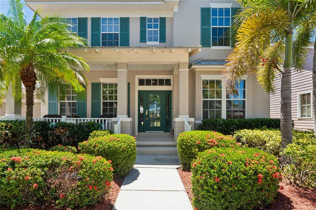 A two-story house with a front porch, teal shutters, and a landscaped walkway — 5714 SEA TROUT PLACE, APOLLO BEACH, FL