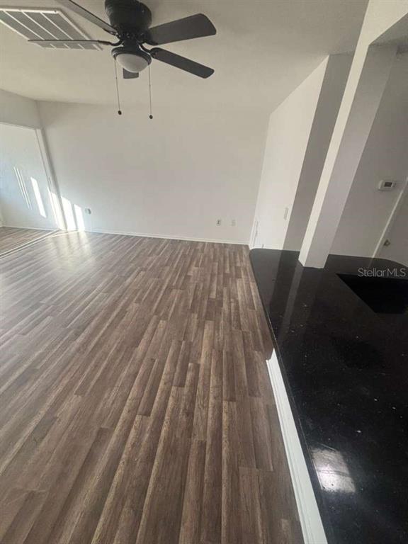 An interior view shows a room with wood-look flooring, a ceiling fan, and a kitchen counter — 3824 N LAKE DRIVE UNIT 108, TAMPA, FL