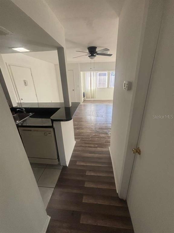 A view from a hallway looking into a kitchen with dark countertops and wood flooring — 3824 N LAKE DRIVE UNIT 108, TAMPA, FL